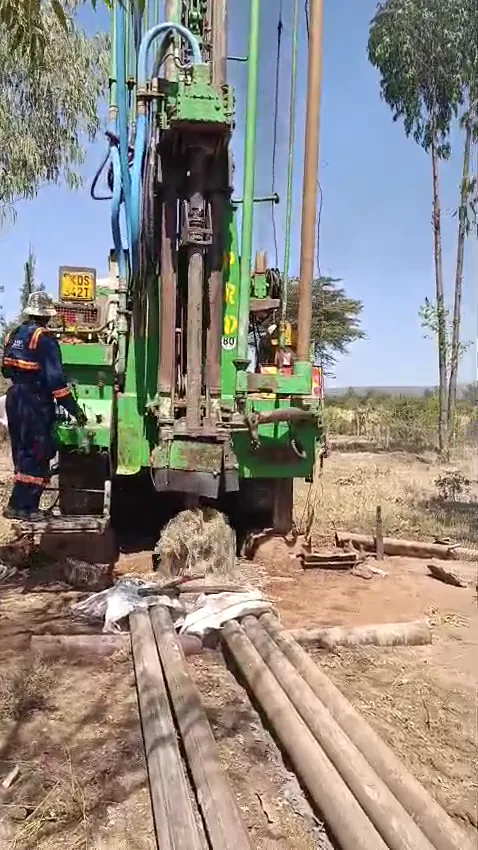 Green borehole drilling rig working at a Kenyan site